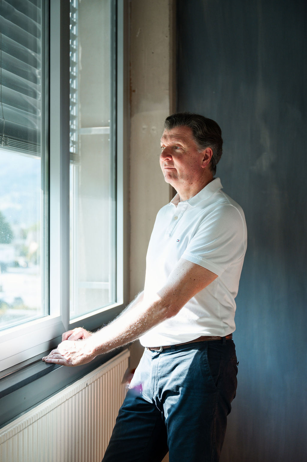 Christian Eibl steht an einem Fenster und blickt nach draußen.